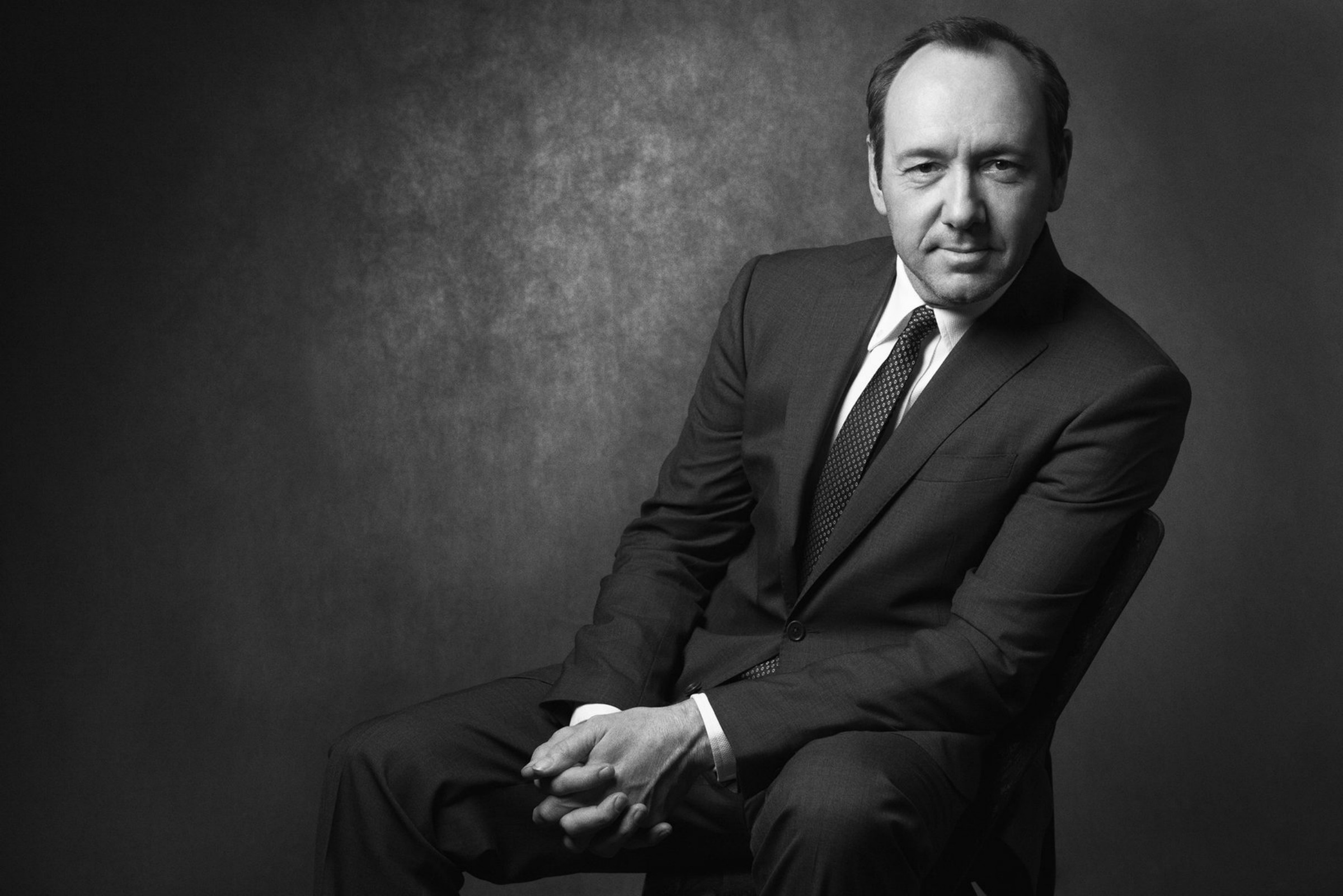 Black and white seated portrait in a suit