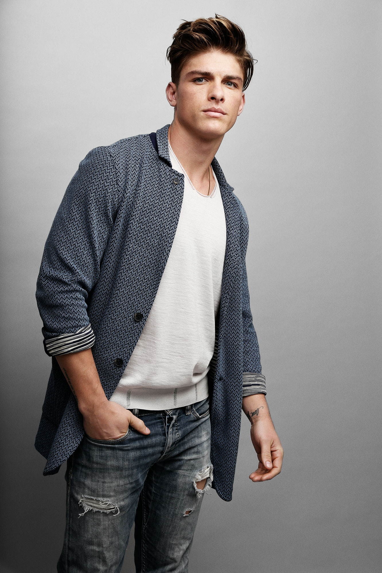 Standing portrait in a blue patterned blazer and jeans